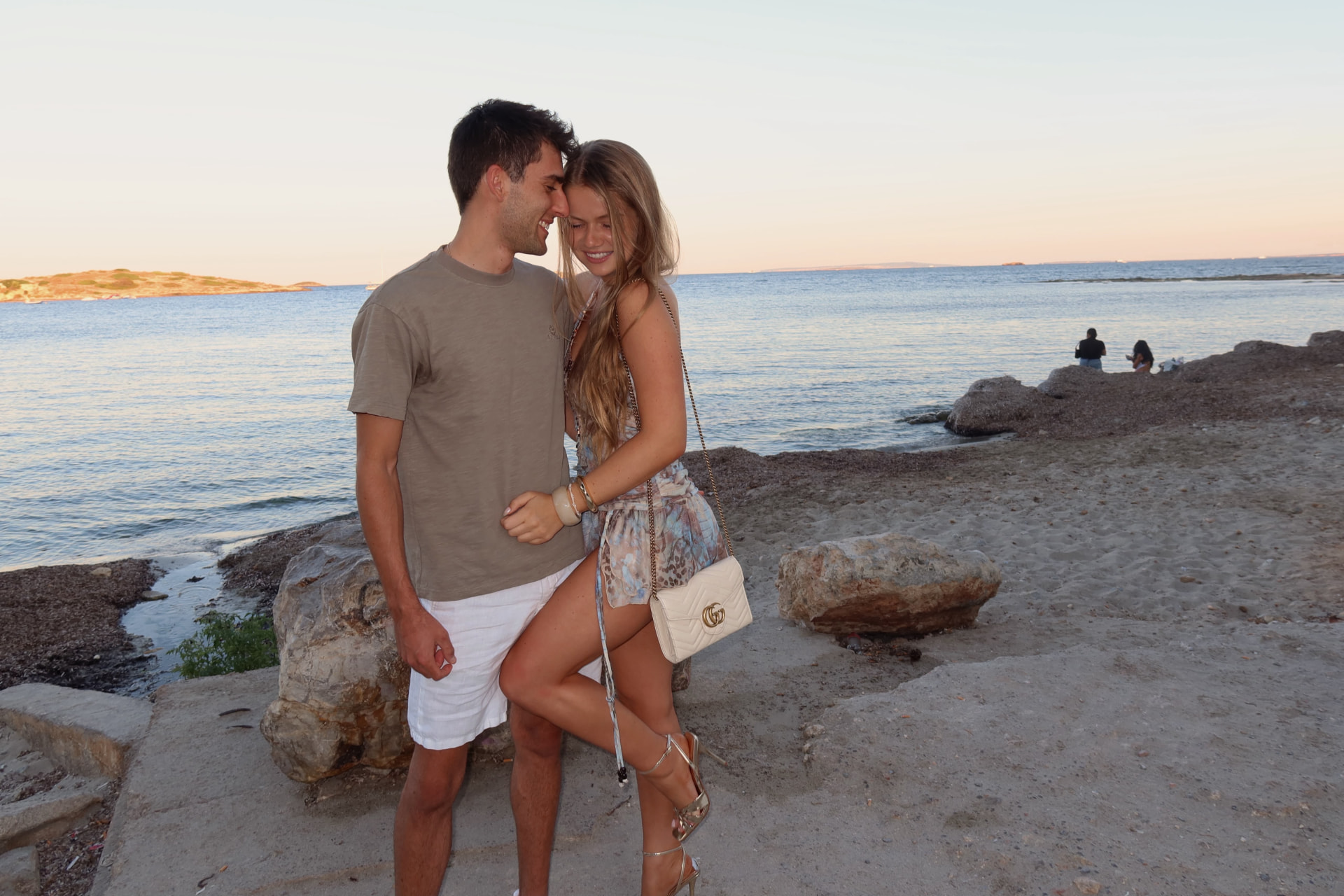 Richard and Maggie on a rocky shoreline at golden hour